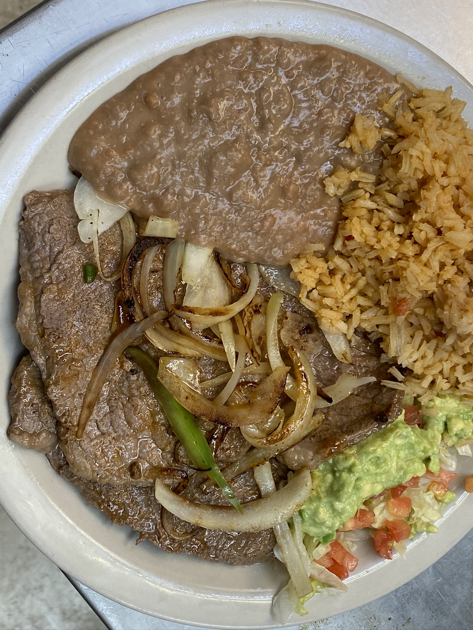 Carne asada plate with rice, beans, and grilled onions at Leah's Mexican Restaurant