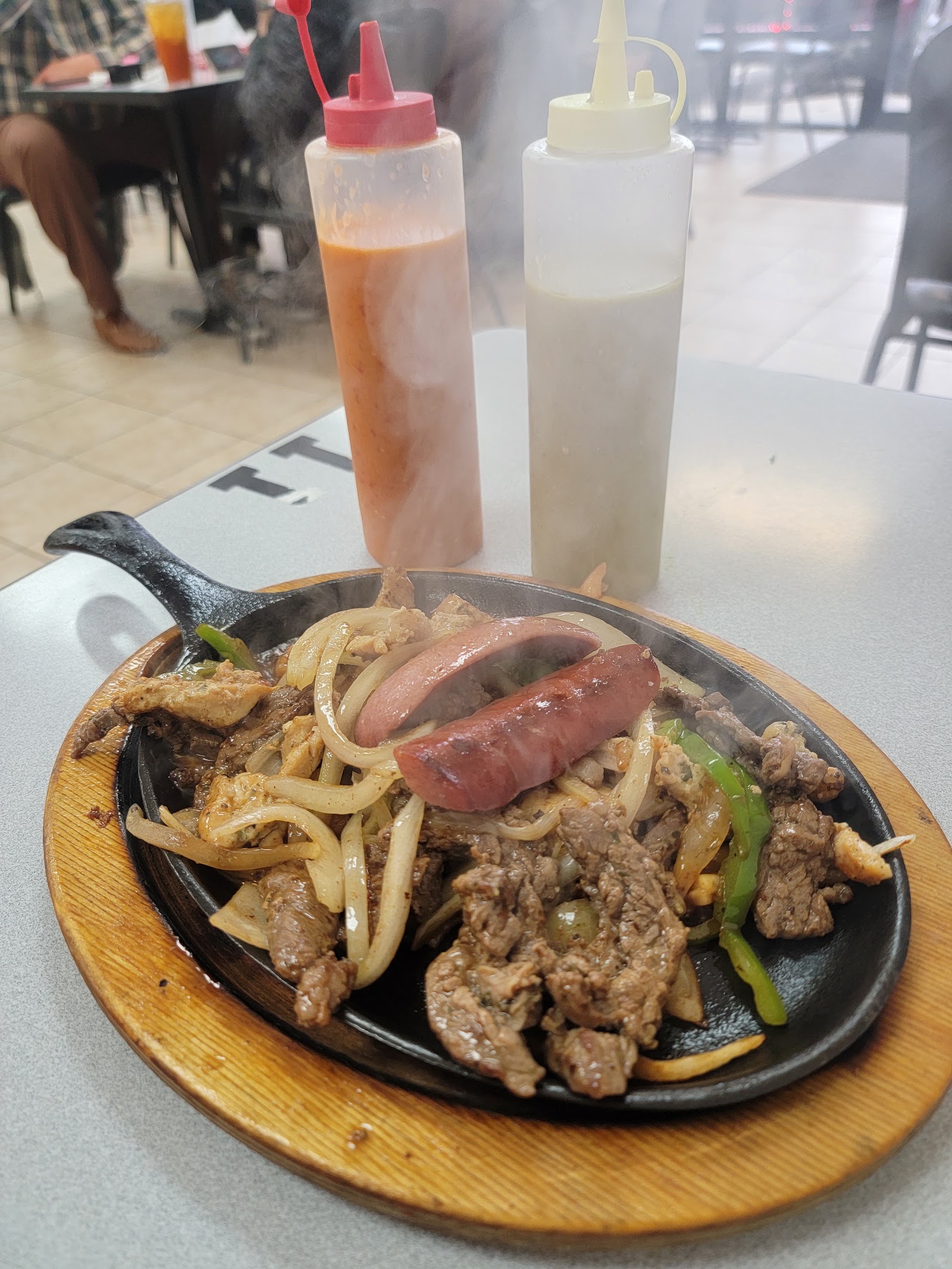 Sizzling fajita skillet with steak, chicken, and sausage at Leah's Mexican Restaurant